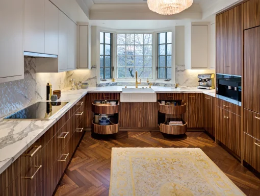 Modern kitchen with wooden cabinets, marble countertops, and a large window.